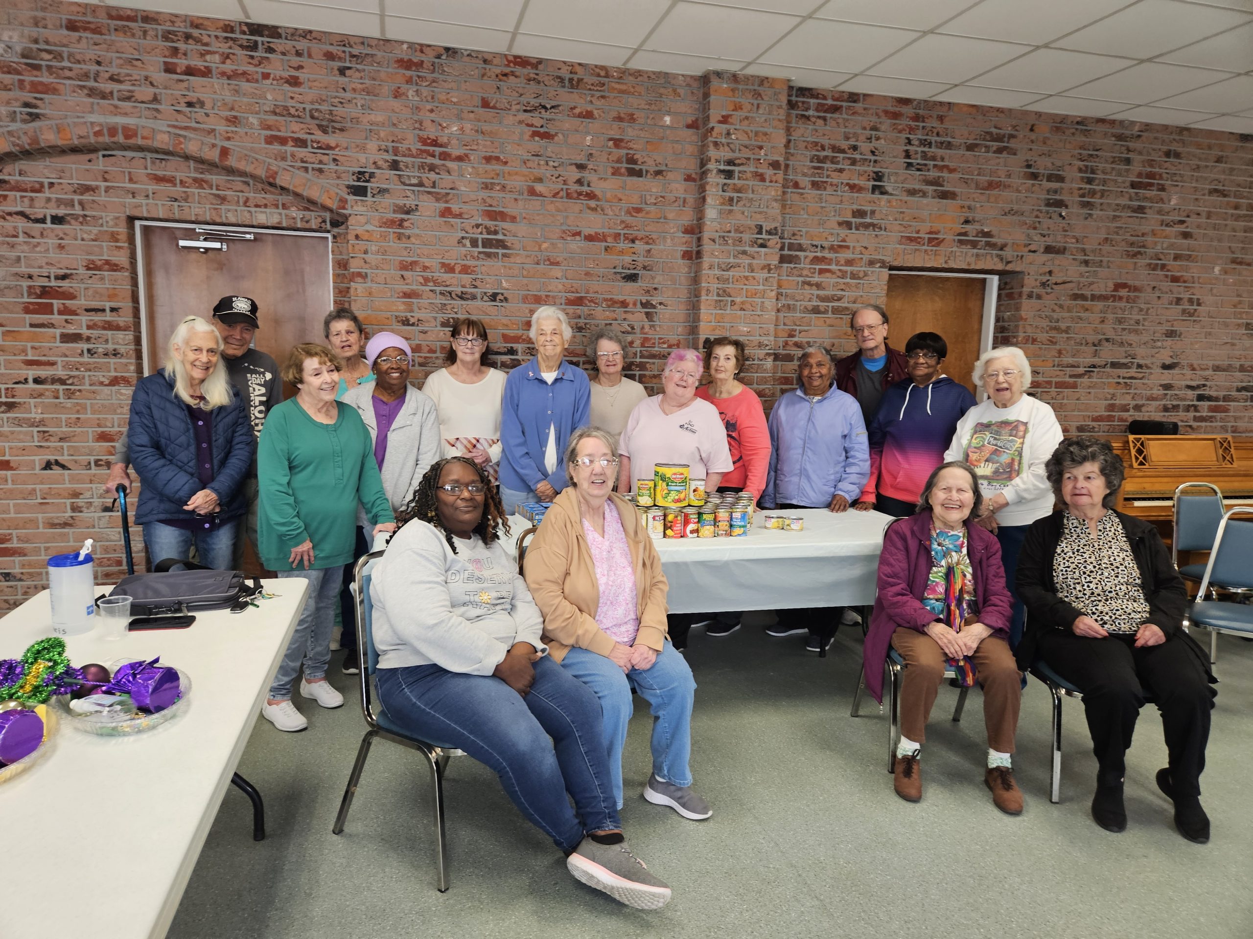 Group of senior center members gathered together with canned food donations at the Ocean Springs Senior Center