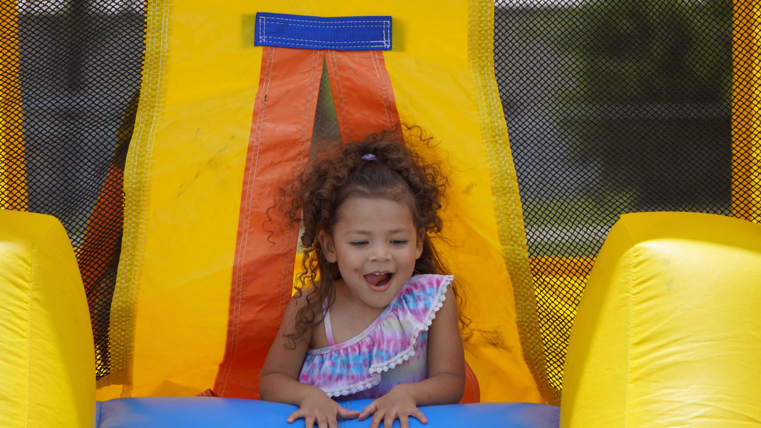 A young girl playing in a bounce house at a CASOMS community event