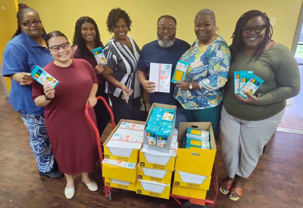 CASOMS Harrison County team holding boxes of school supplies and materials ready to pack into backpacks for the back to school distribution event